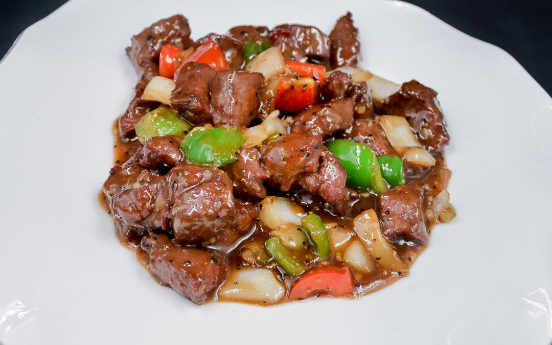 Sauteed beef fillets with onions on hot plate